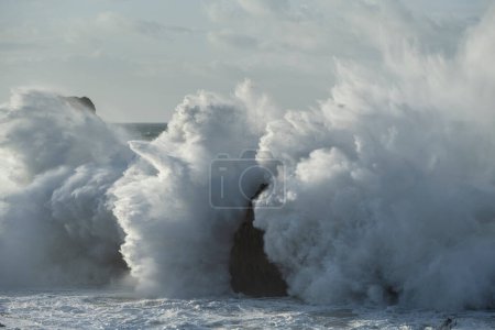 Foto de Large winter waves crash overy rocky coastline at Playa de la Arnia, Cantabria, Spain - Imagen libre de derechos