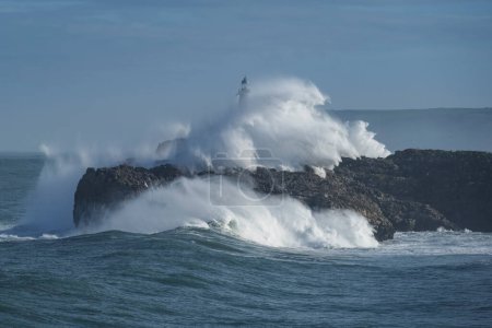 Foto de Large winter wave crashes over Faro de Mouro lighthouse, Santander, Spain - Imagen libre de derechos
