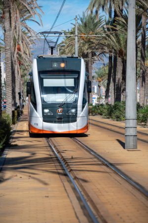 Photo for Alicante, Spain : 2022 November 17 : Alicante Metropolitan TRAM along the Paseo Maritimo de San Juan in Alicante in 2022. - Royalty Free Image