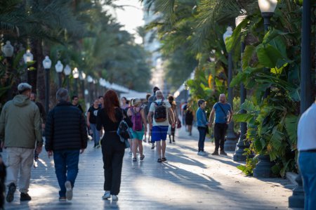 Téléchargez les photos : Alicante, Espagne : 2022 18 novembre : Personnes marchant sur le Paseo Maritimo dans la ville touristique d'Alicante en Espagne en 2022. - en image libre de droit