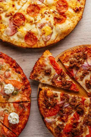 Téléchargez les photos : Pizza on a wooden table, several types - en image libre de droit