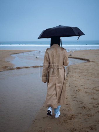 Téléchargez les photos : Young girl walking on the beach nearly Atlantic Ocean - en image libre de droit