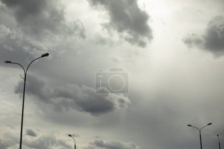 Téléchargez les photos : Light pole against sky. Celestial landscape in cloudy weather. Minimalism of urban environment. - en image libre de droit