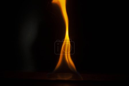 Photo for Flames in dark. One flame on black background. Ignition details. Fire burns yellow. Evaporation of alcohol. - Royalty Free Image