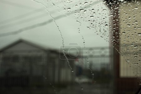 Téléchargez les photos : Des gouttes de pluie sur verre. Météo pluvieuse fenêtre extérieure. - en image libre de droit