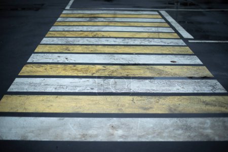 Téléchargez les photos : Pedestrian crossing across road in rain. Road markings for pedestrians. Strips in row on asphalt. Paint on road. - en image libre de droit