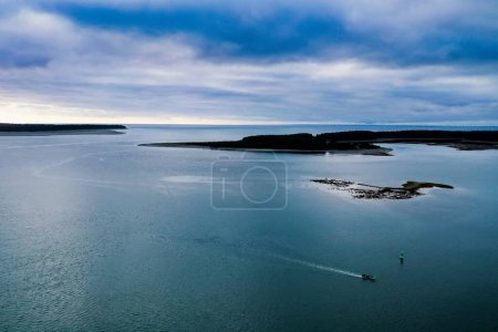 Foto de Boat goes across ocean bay with blue waters and sky - Imagen libre de derechos