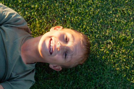 Photo for The boy lying on the grass of the golf course on Tenerife island. - Royalty Free Image