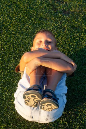 Photo for The boy lying on the grass of the golf course on Tenerife island. - Royalty Free Image