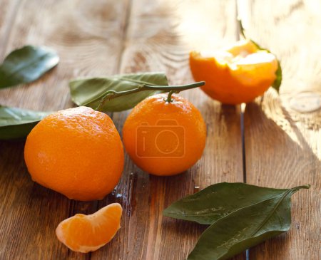 Téléchargez les photos : Washed tangerines with leaves lie on the table - en image libre de droit