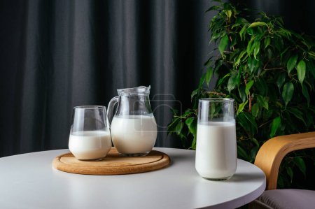 Téléchargez les photos : Milk in a glass on a white table - en image libre de droit