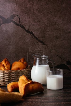 Photo for Pasties stuffed and glass of milk on a dark background. - Royalty Free Image