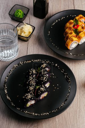 Téléchargez les photos : Several types of sushi rolls in plates on the table. soy sauce, wasabi. asian restaurant menu - en image libre de droit