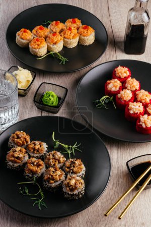 Foto de Several types of sushi rolls in plates on the table. soy sauce, wasabi. asian restaurant menu - Imagen libre de derechos