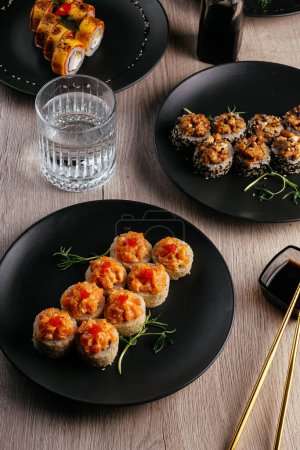 Téléchargez les photos : Several types of sushi rolls in plates on the table. soy sauce, wasabi. asian restaurant menu - en image libre de droit