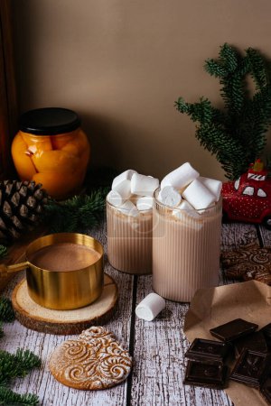 Foto de Glass with hot chocolate and marshmallows and gingerbread cookies on wooden background. Christmas concept - Imagen libre de derechos