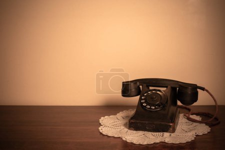Foto de Vintage telephone onl ace napkin wooden table. - Imagen libre de derechos