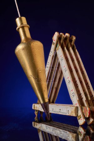 Photo for Plumb bob & carpenter's scale, antique surveying equipment - Royalty Free Image