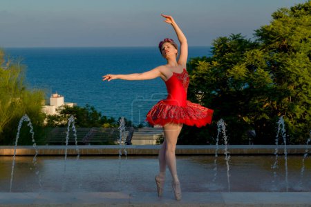 Foto de Young ballet dancer with red outfit dancing outdoors with her red outfit - Imagen libre de derechos