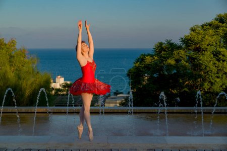 Photo for Young ballet dancer with red outfit dancing outdoors with her red outfit - Royalty Free Image