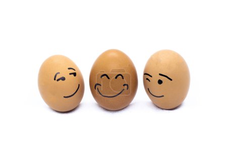 Foto de Two eggs flirting and one very happy on white background - Imagen libre de derechos