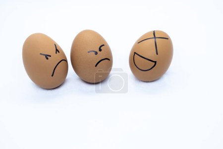 Photo for Two angry eggs watching an egg laughing - Royalty Free Image