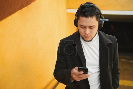 Photo for An Asian guy in a headphones rises from the underpass - Royalty Free Image