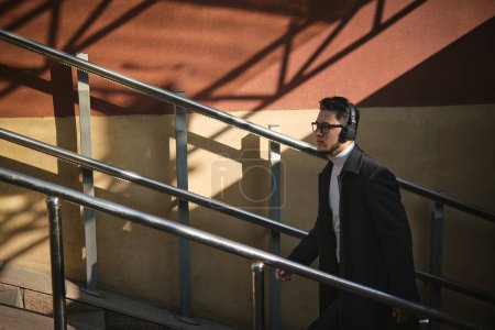 Photo for An Asian guy in a headphones rises from the underpass - Royalty Free Image