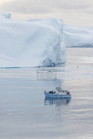 Téléchargez les photos : Small ship sailing between white icebergs - en image libre de droit
