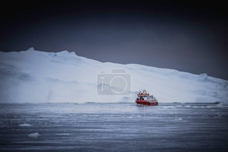 Téléchargez les photos : Small boat sailing between icebergs - en image libre de droit
