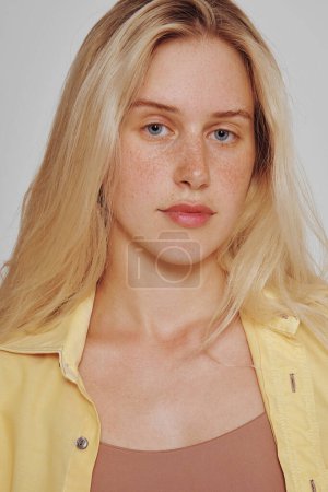 Foto de Portrait of natural blonde woman with freckles and long hair. Girl looking at the camera - Imagen libre de derechos