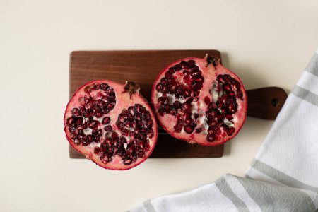 Foto de Pomegranate Halves on Wooden Board on Kitchen CounterHealthy Lifestyle - Imagen libre de derechos