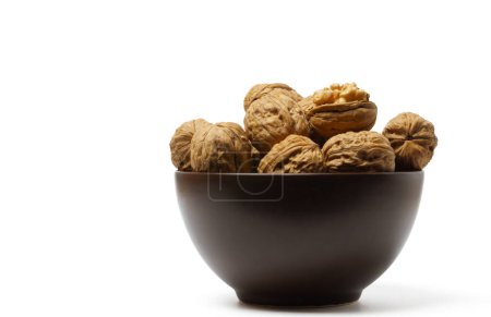 Téléchargez les photos : Walnuts in a brown bowl isolated on a white background - en image libre de droit