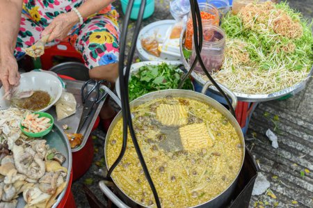 Foto de Vietnamese woman preparing beef soup bowl at street food stall i - Imagen libre de derechos