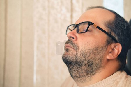 Téléchargez les photos : A European man in glasses and headphones sleeping at workplace - en image libre de droit