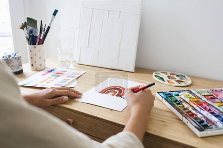Téléchargez les photos : Person Painting with Watercolor on Desk With Art Materials - en image libre de droit