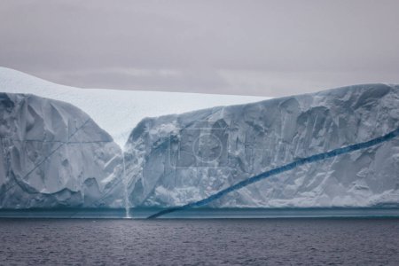 Téléchargez les photos : Little waterfall over big iceberg - en image libre de droit