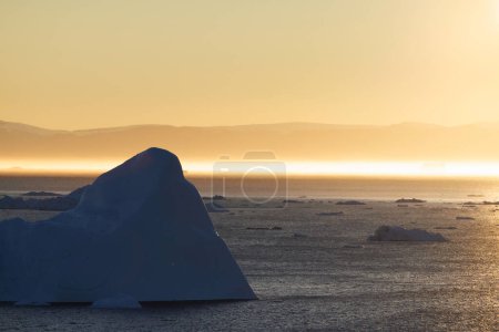 Foto de Sun reflections near big icebergs floating over sea - Imagen libre de derechos