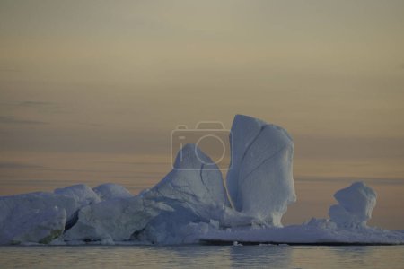 Téléchargez les photos : Gros icebergs flottant au-dessus de la mer au coucher du soleil - en image libre de droit
