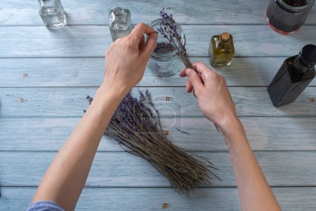 Téléchargez les photos : Young woman making homemade lavender essential oil. Top View. - en image libre de droit