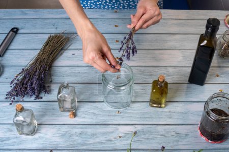 Photo for Young woman making homemade lavender essential oil. Top View. - Royalty Free Image