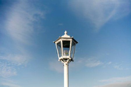 Foto de Close up of white old street lamp isolated on blue sky - Imagen libre de derechos