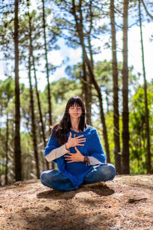 Photo for Front view of a woman meditating with her arms on her chest - Royalty Free Image
