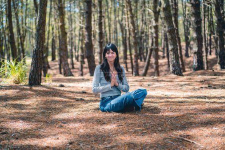 Photo for A woman clasping hands in the woods. Namaste pose. - Royalty Free Image