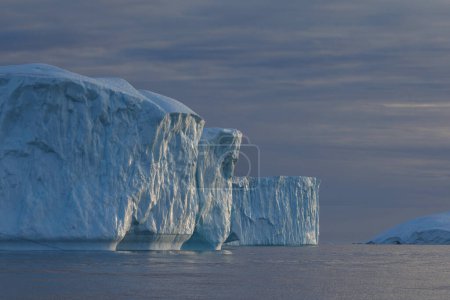 Téléchargez les photos : Sun reflections in big icebergs floating over sea - en image libre de droit