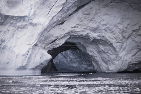 Téléchargez les photos : Cave in big iceberg floating over sea - en image libre de droit