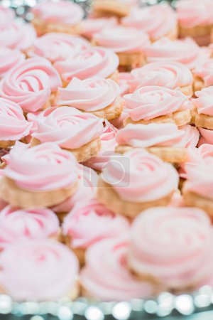 Téléchargez les photos : Repeating rows of cupcakes with pink frosting at a tea party - en image libre de droit