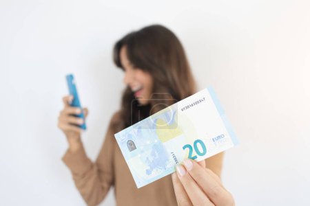 Foto de Earn Money Online Woman Holding Smartphone and Cash Euro Bill - Imagen libre de derechos