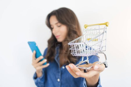 Foto de Person Shopping Online Shopping Cart and Smartphone - Imagen libre de derechos
