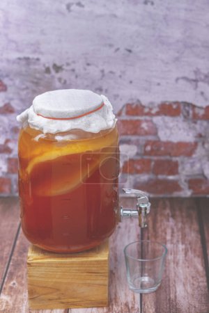Téléchargez les photos : Glass jar with homemade kombucha, scoby, with a tap for serving - en image libre de droit